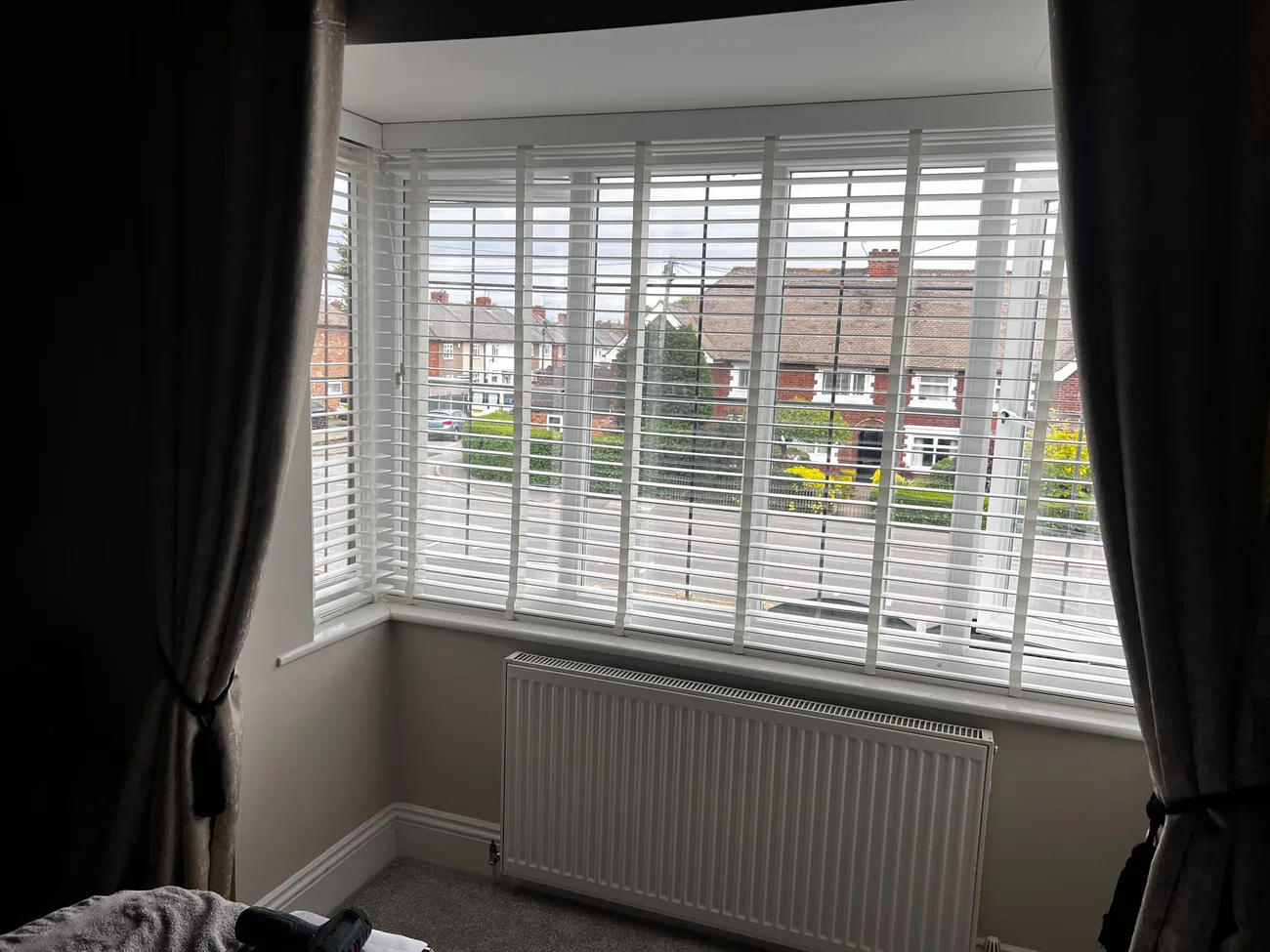 An alternative angle of white slatted blinds fitted to the bay window