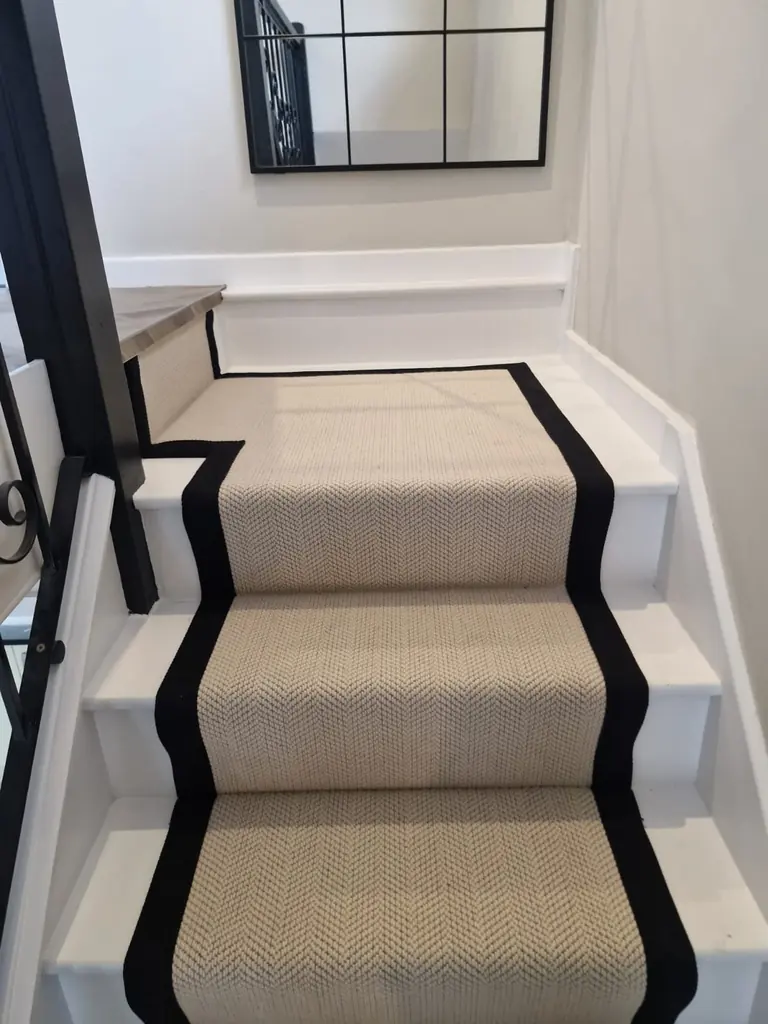 Pale stair runner with black border fitted around a turn