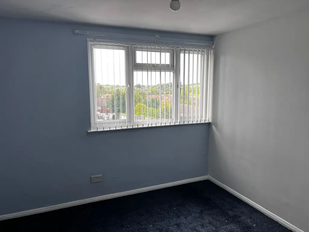 Wider view of white vertical blinds in the blue-walled room