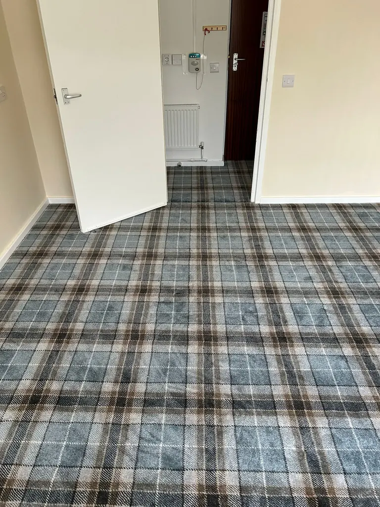 Blue and grey check carpet fitted beside an open doorway