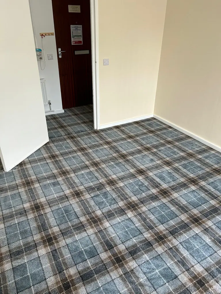 Check-pattern carpet across the room and doorway