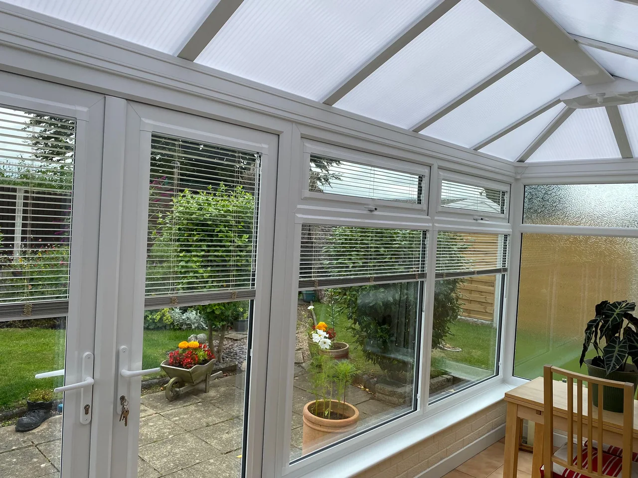 Matching slatted blinds across conservatory windows and doors