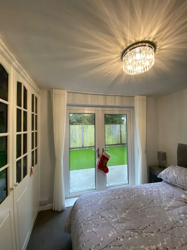 Cream full-length curtains drawn back beside glazed garden doors