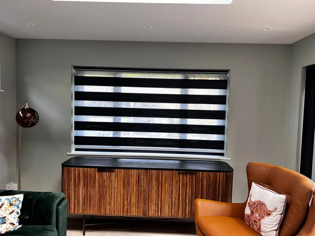 Black and sheer striped day and night blind fitted in a sitting room