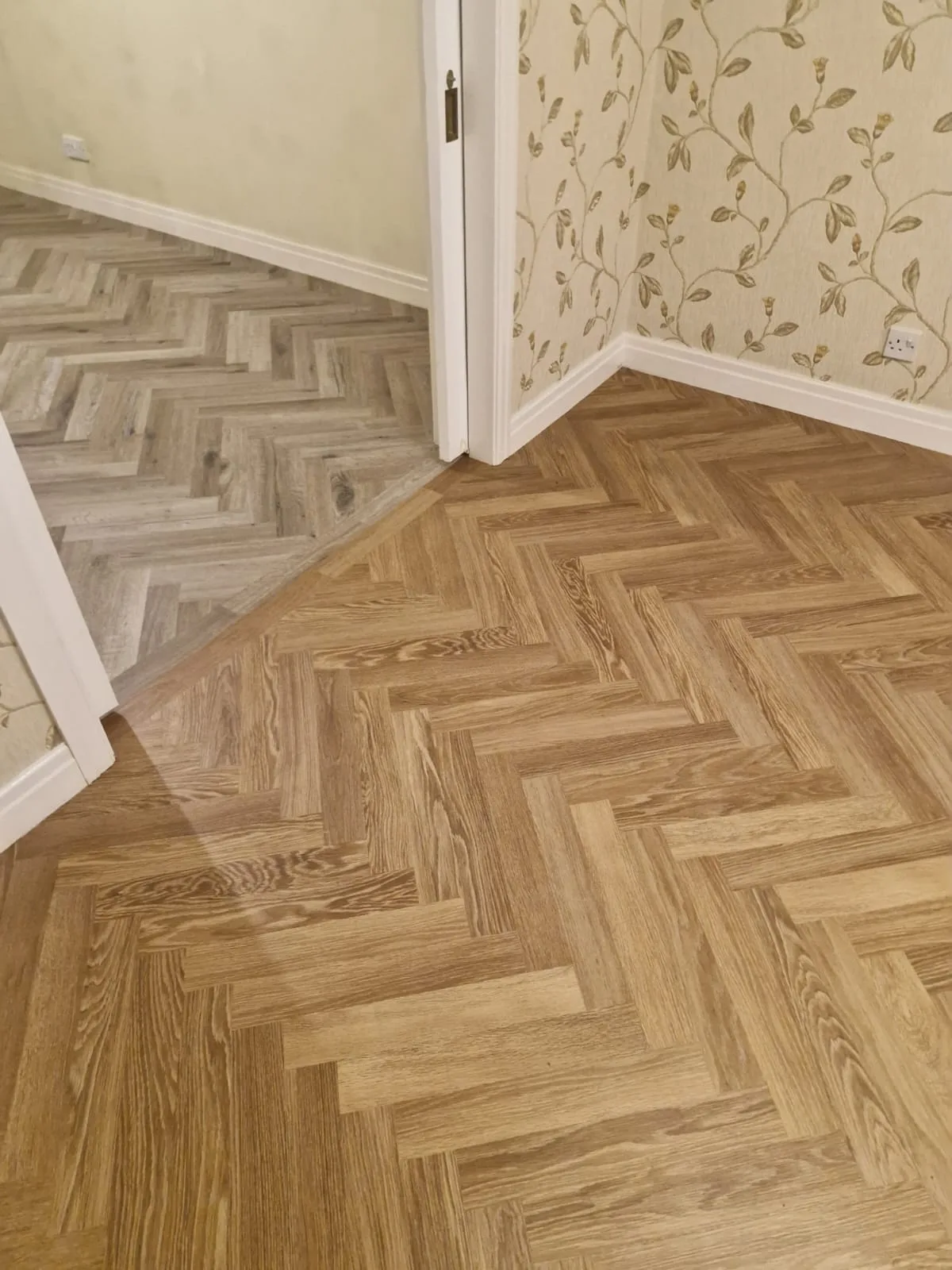 Detail of the completed herringbone floor continuing through a doorway