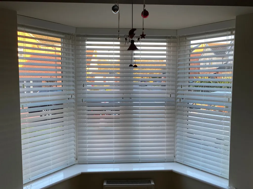 Second view of white fitted bay blinds and pendant lights
