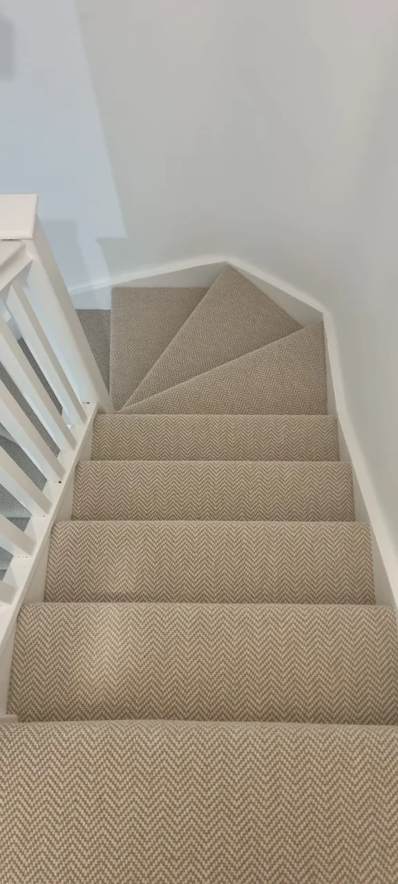 The same light textured stair carpet seen from the top of the turn